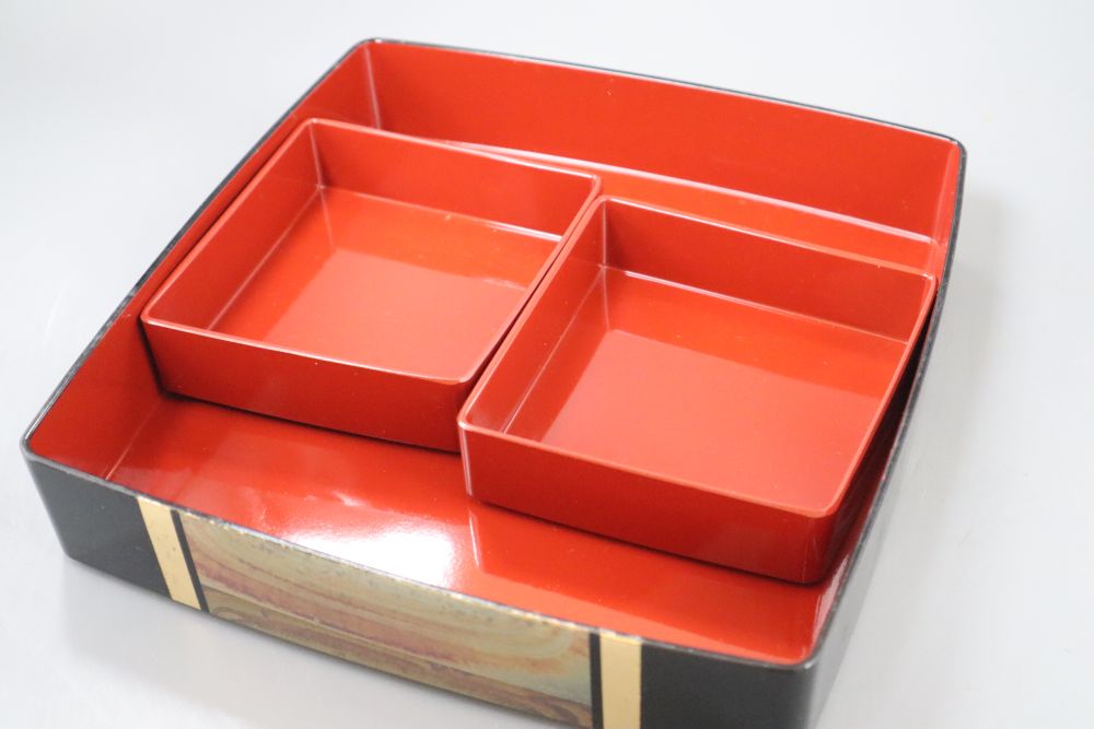 A 20th century Japanese lacquer picnic box and a Belemnite dish